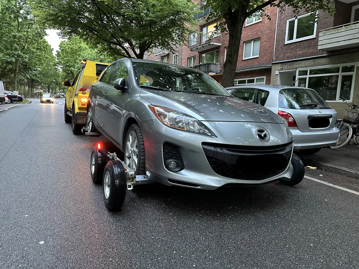 Auto auf Rangierrollern in einer engen Altbaustraße in Hamburg