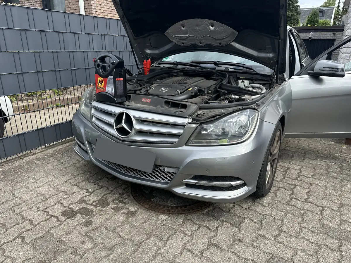 Pannenhilfe am geöffneten Motorraum eines Autos in Hamburg